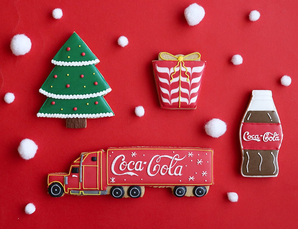 Coca-Cola themed Christmas biscuits by Biscuiteers, featuring iconic symbols like the Christmas Truck and Cola Bottle for personalized gifts.