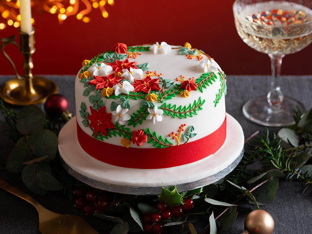 Festive Biscuiteers Christmas cake with hand-iced flowers, perfect for holiday celebrations and personalized gifts.