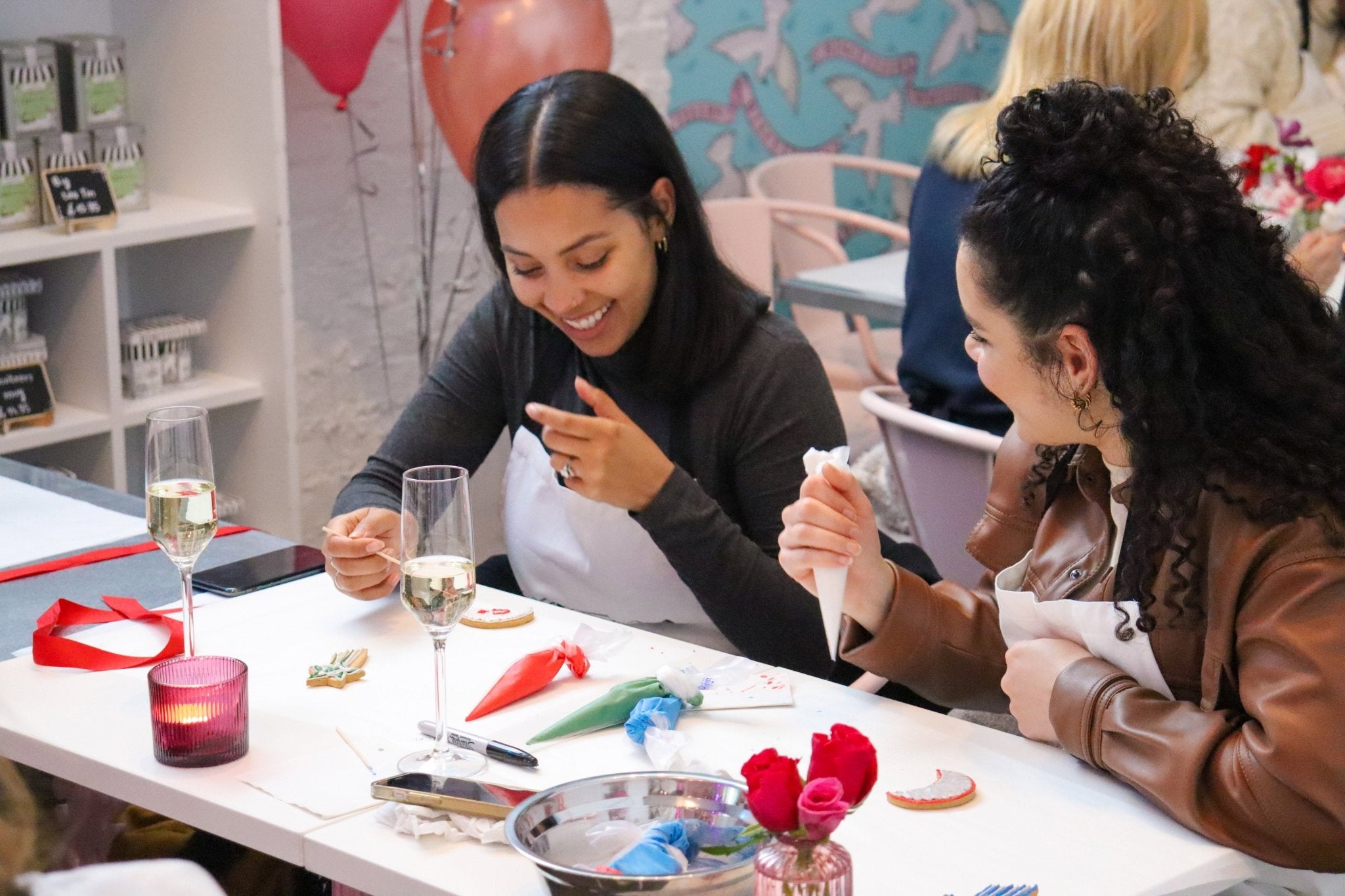 Biscuiteers icing class: guests enjoy bubbly, decorate biscuits, and receive aprons at Notting Hill and Belgravia cafes.