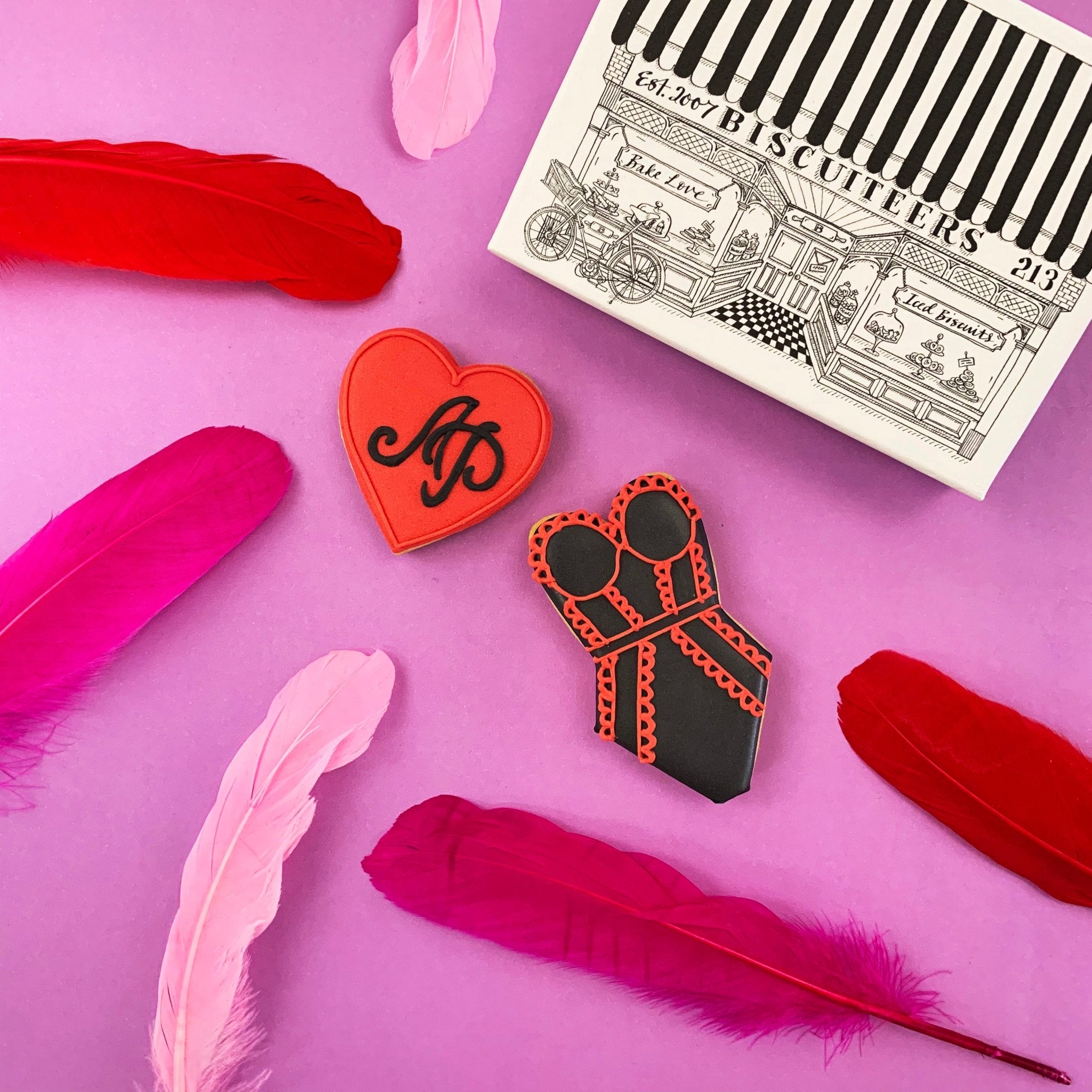 Agent Provocateur VIP launch gift: red heart biscuit with logo, black lingerie design by Biscuiteers for corporate gifting.