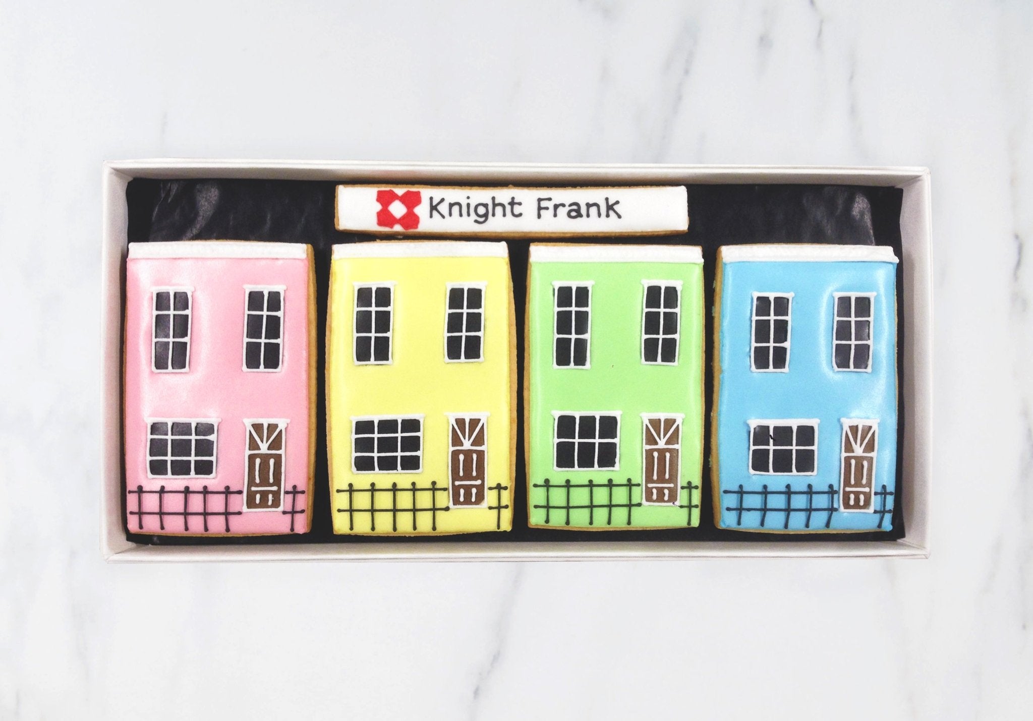 Knight Frank bespoke biscuits by Biscuiteers, featuring pastel houses and logo, perfect for unique client gifts and hassle-free delivery.