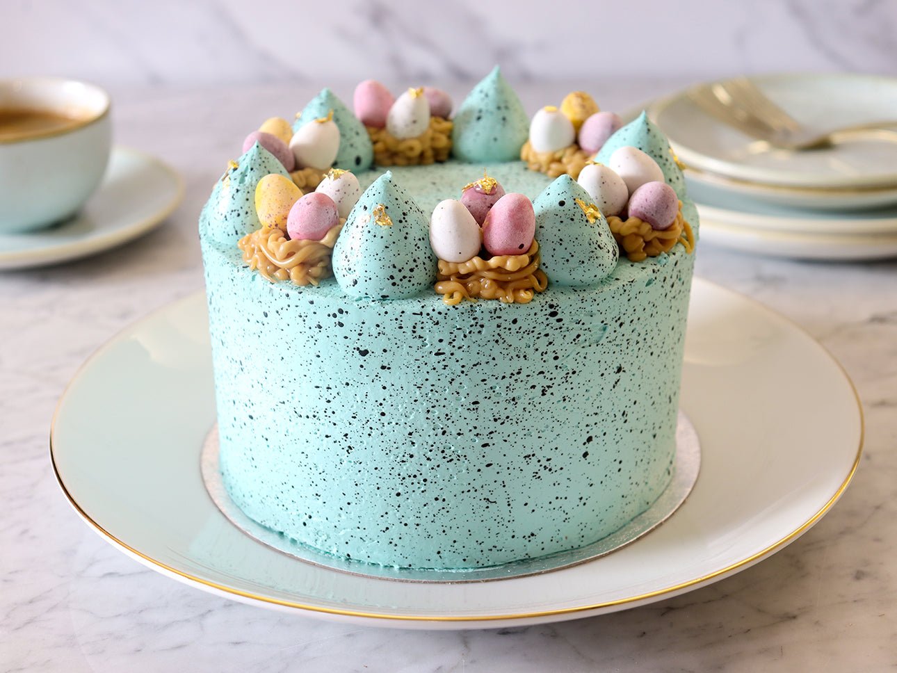 Easter chocolate cake with pastel blue buttercream and mini eggs, perfect for spring celebrations and Biscuiteers gifts.