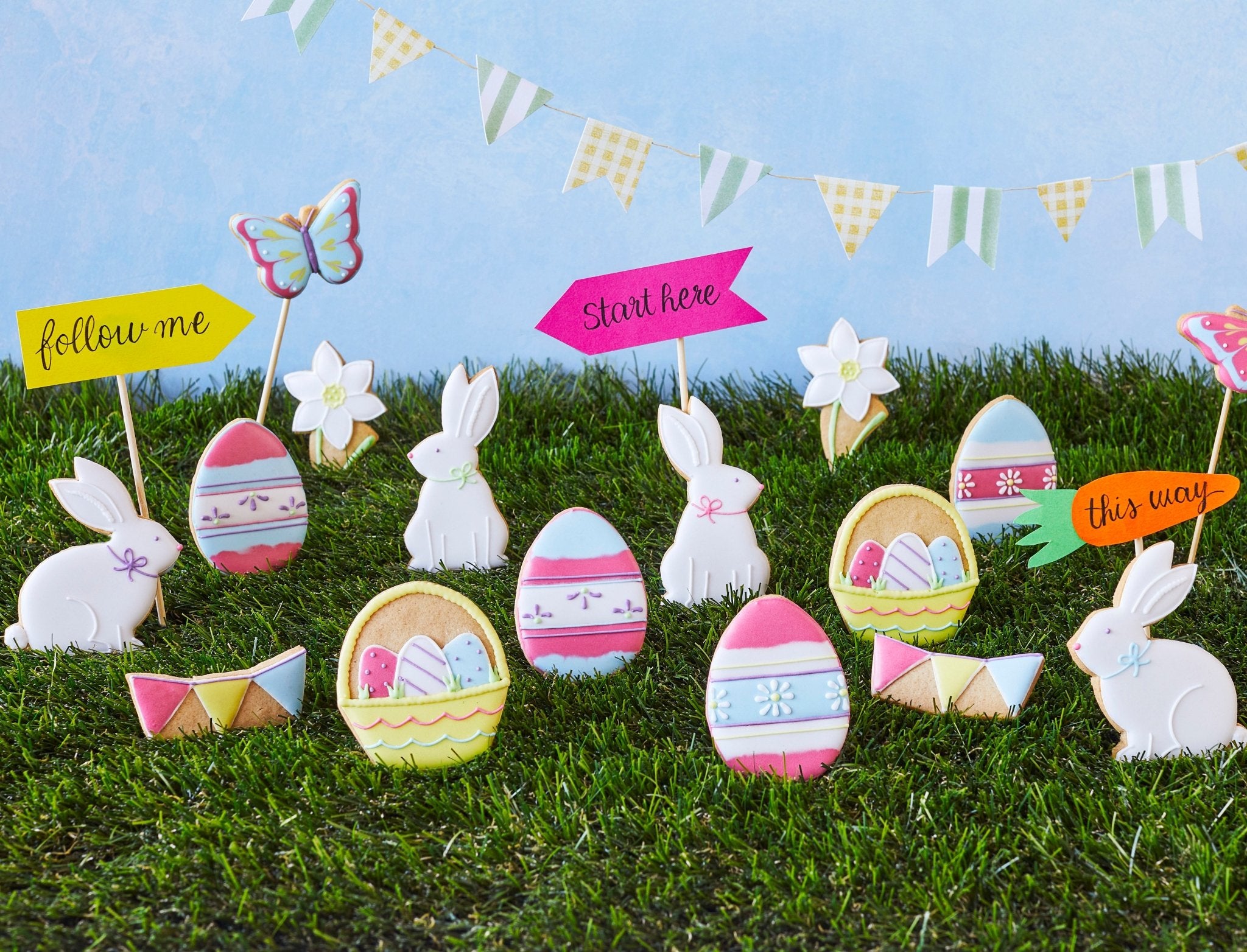 Colorful Easter egg hunt scene with Biscuiteers' hand-iced biscuits, perfect for spring crafts and personalized gifts.