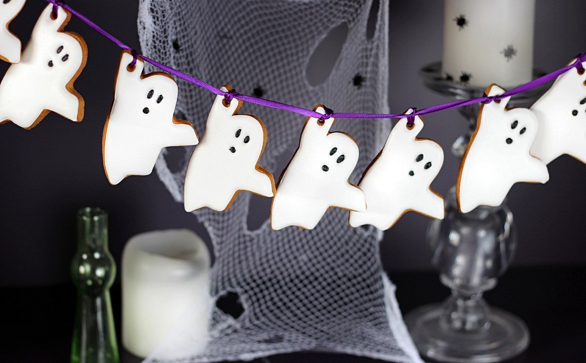 Halloween red velvet cake with chocolate spider web design, perfect for spooky celebrations and Biscuiteers' personalized gifts.