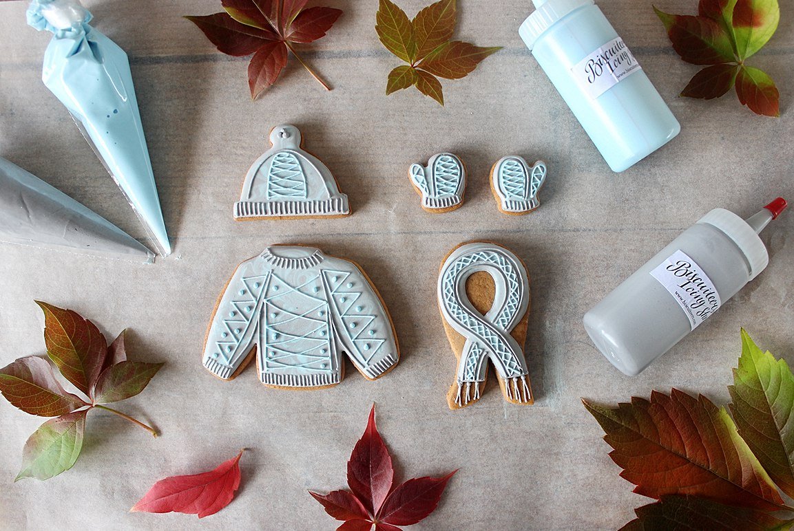Autumn-themed gluten-free biscuits shaped like woolly hats and mittens, perfect for personalized gifts by Biscuiteers.
