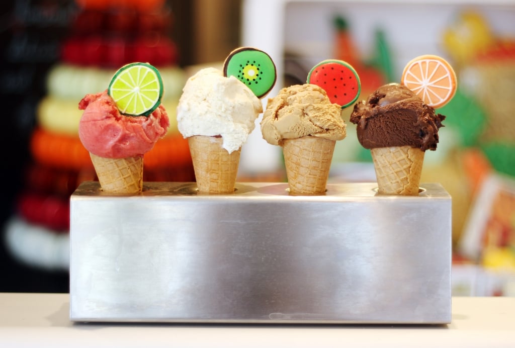 Colorful ice cream cones with biscuit toppers, perfect for summer celebrations at Biscuiteers' icing cafes.