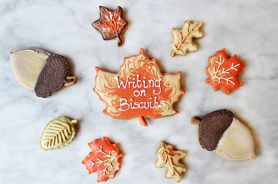 Autumn-themed biscuits with royal icing writing, perfect for personalized gifts by Biscuiteers.