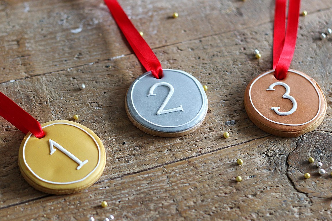 Olympic-themed biscuits with metallic paint, perfect for Rio party favors. Personalised gifts by Biscuiteers.