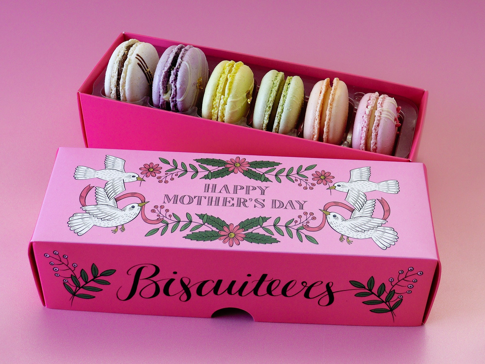 Hand-iced Biscuiteers macarons for Mother's Day, featuring raspberry, rose, and white chocolate, perfect personalized gifts.