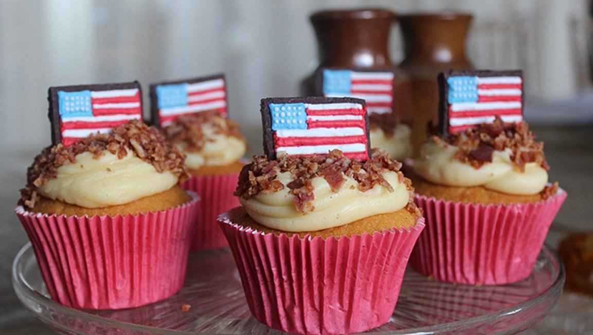 Thanksgiving maple buttercream cupcakes with bacon sprinkles by Biscuiteers, perfect for festive personalized gifts.